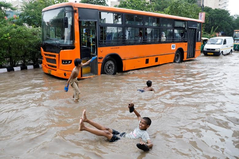 Children play on a flooded street after heavy rains in New Delhi. REUTERS/Adnan Abidi
